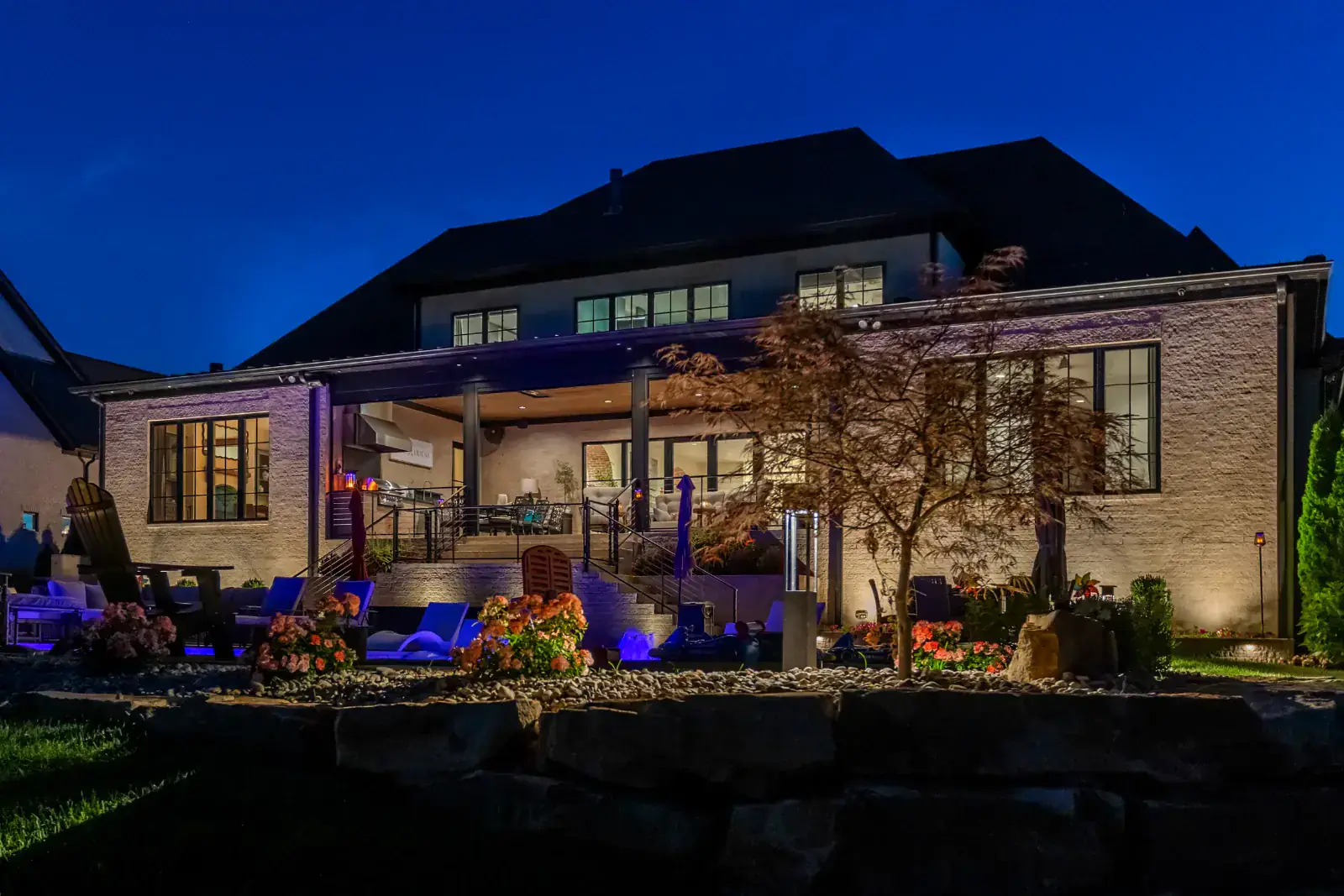 A Middle Tennessee home backyard patio and terrace lit at night with landscape and architectural lighting